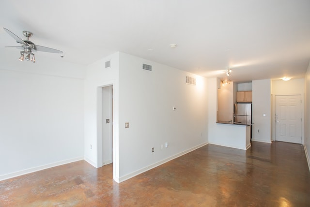 unfurnished living room with ceiling fan and concrete flooring