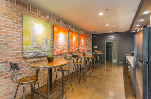 dining space featuring brick wall