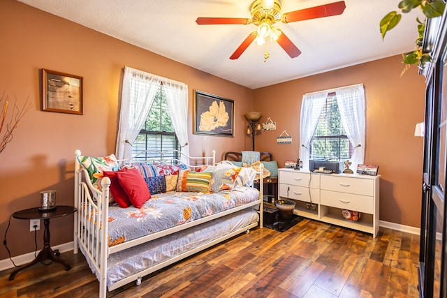 bedroom with ceiling fan, baseboards, and hardwood / wood-style flooring