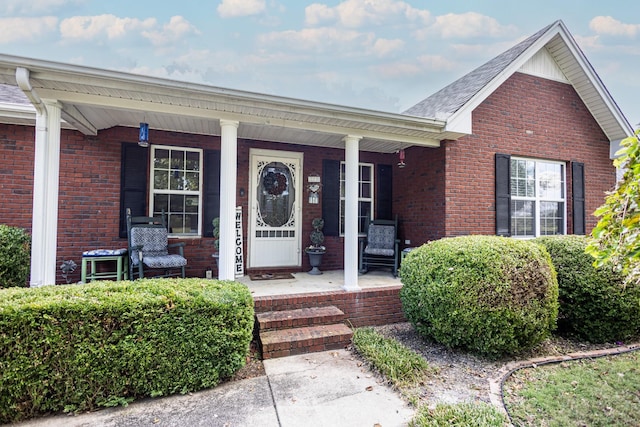 property entrance featuring brick siding and covered porch