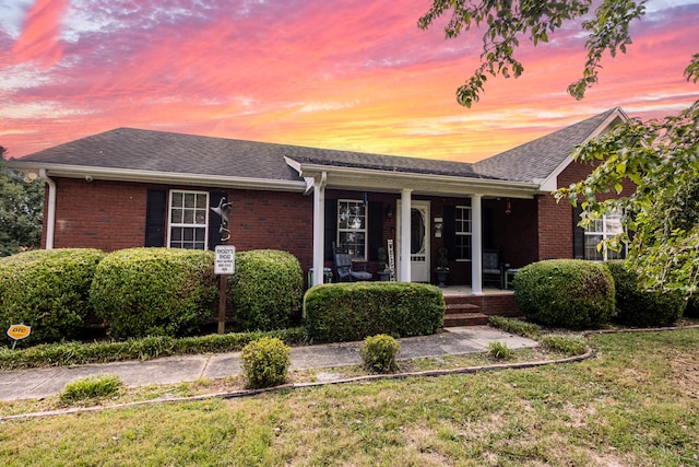 ranch-style house featuring a yard and a porch