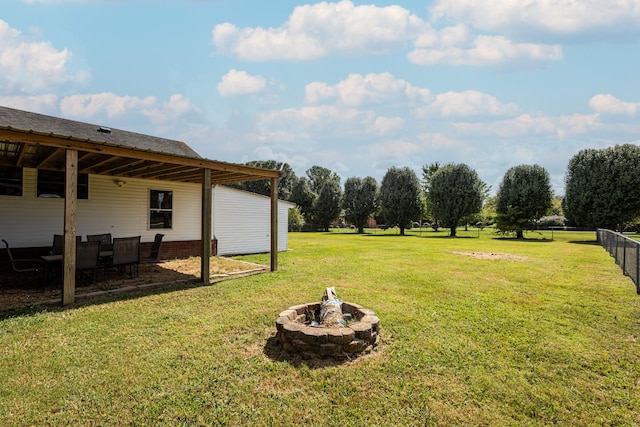 view of yard with fence and an outdoor fire pit