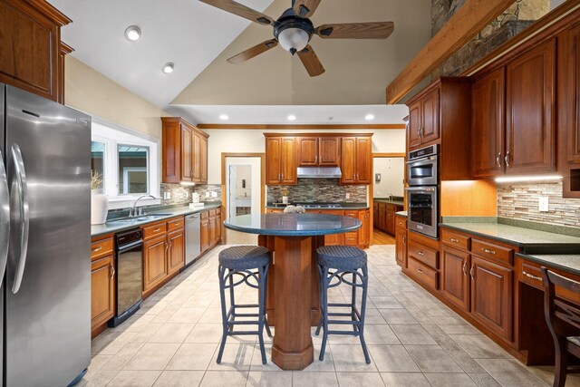 kitchen with tasteful backsplash, a kitchen island, stainless steel appliances, lofted ceiling, and a breakfast bar