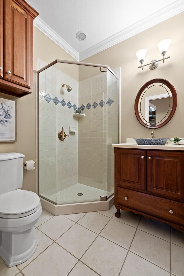 bathroom with tile patterned floors, toilet, crown molding, vanity, and walk in shower