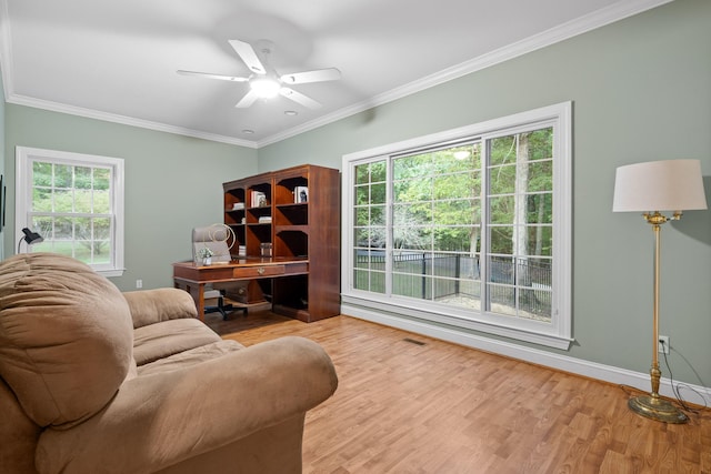 living room with crown molding, light hardwood / wood-style flooring, and ceiling fan