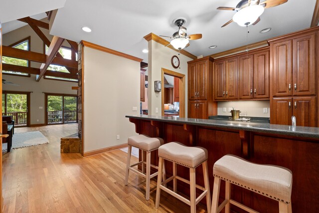 bar with ceiling fan, lofted ceiling, and light wood-type flooring