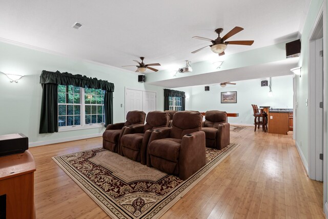 cinema room featuring crown molding and light wood-type flooring