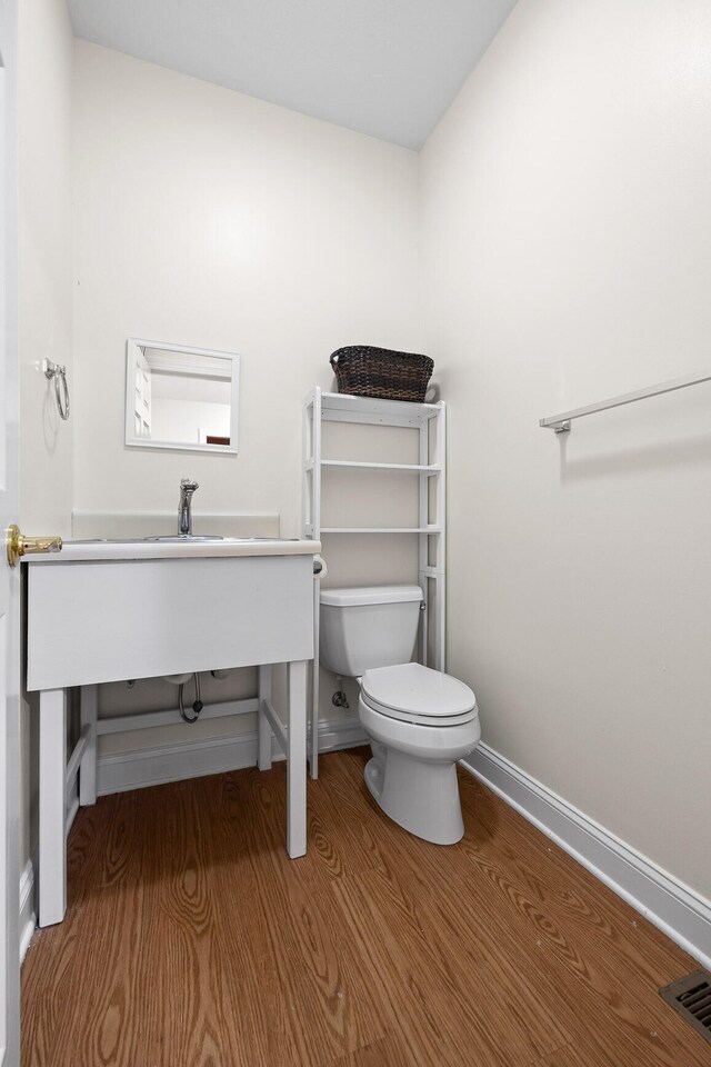 bathroom with wood-type flooring and toilet