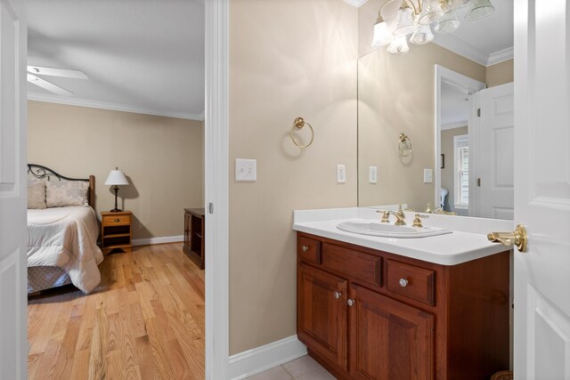 bathroom featuring vanity, ceiling fan, ornamental molding, and hardwood / wood-style floors