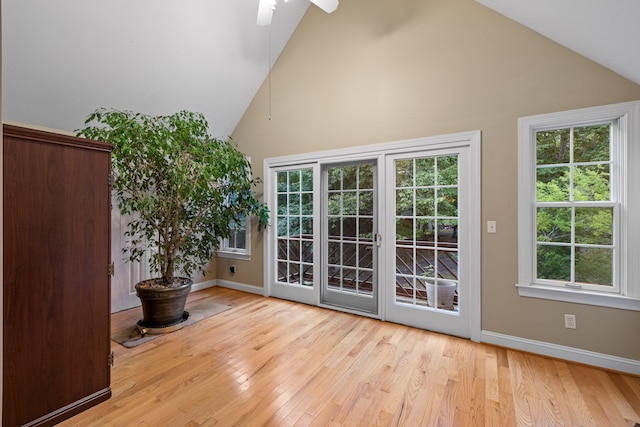 doorway to outside with light hardwood / wood-style floors, high vaulted ceiling, and ceiling fan