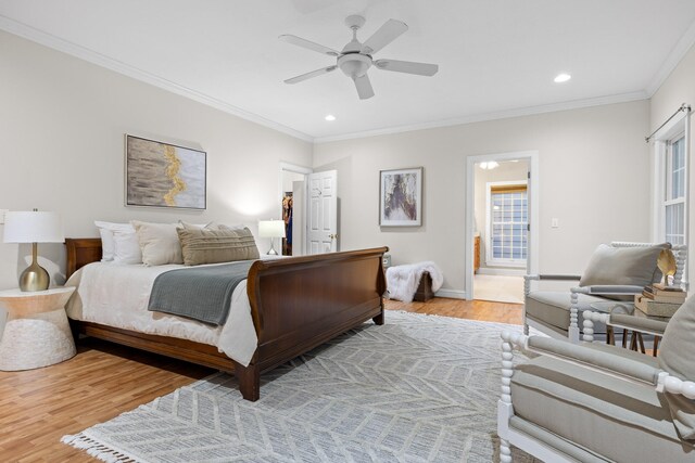 bedroom featuring light hardwood / wood-style floors, ornamental molding, multiple windows, and ceiling fan