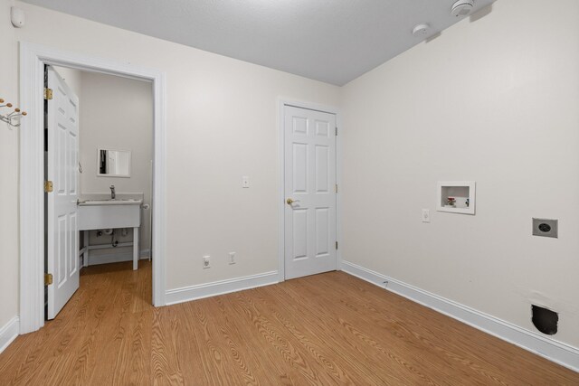 laundry room with light hardwood / wood-style floors, electric dryer hookup, washer hookup, and sink