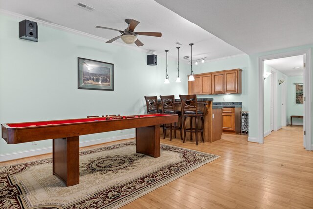 recreation room featuring ornamental molding, light hardwood / wood-style flooring, and ceiling fan