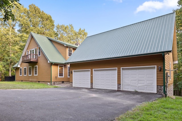 exterior space with a balcony, an outdoor structure, metal roof, and crawl space