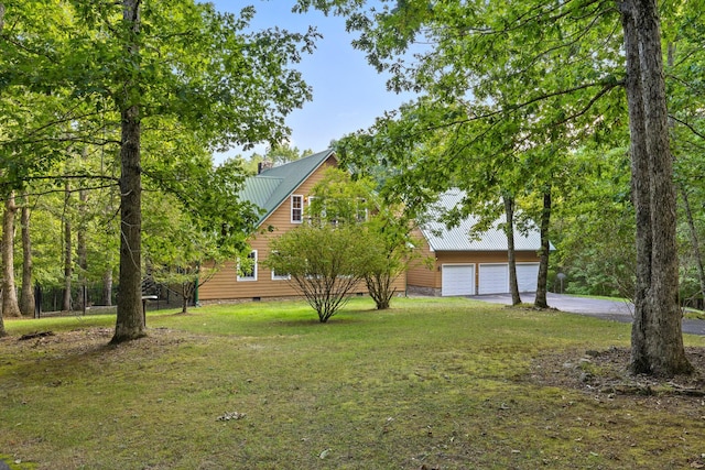 view of yard featuring driveway and a garage