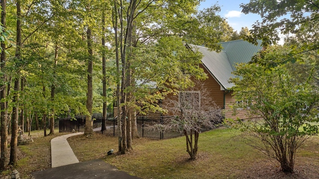 view of side of home with fence and metal roof