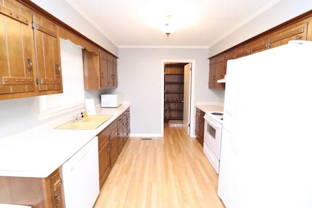 kitchen with white appliances, light hardwood / wood-style flooring, ornamental molding, and sink