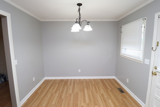 empty room featuring hardwood / wood-style floors, an inviting chandelier, and crown molding