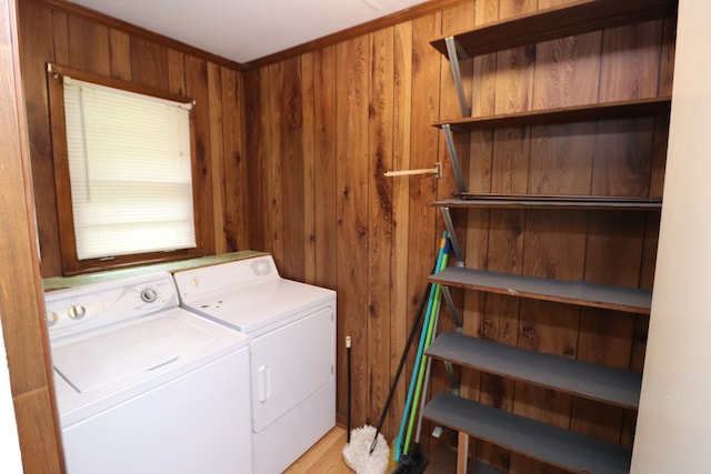 washroom with wooden walls and washing machine and clothes dryer