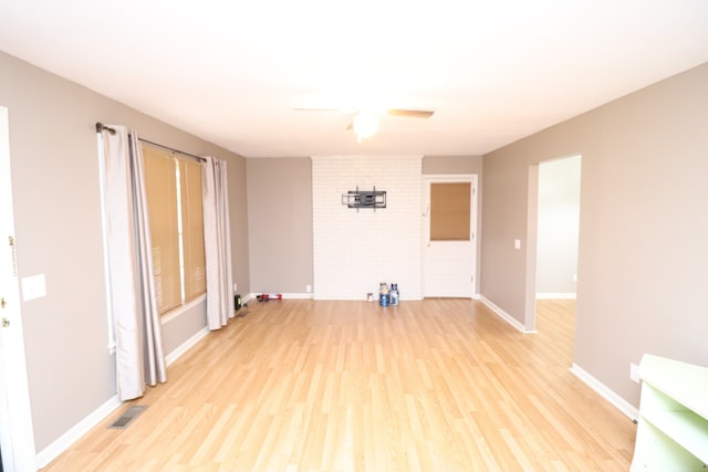 empty room with ceiling fan, light hardwood / wood-style floors, and a fireplace