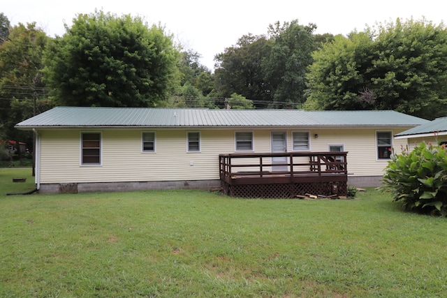 back of house featuring a lawn and a wooden deck