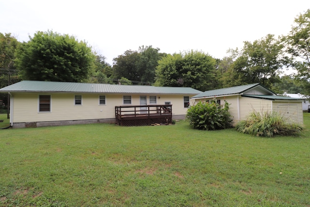 back of property featuring a deck and a lawn