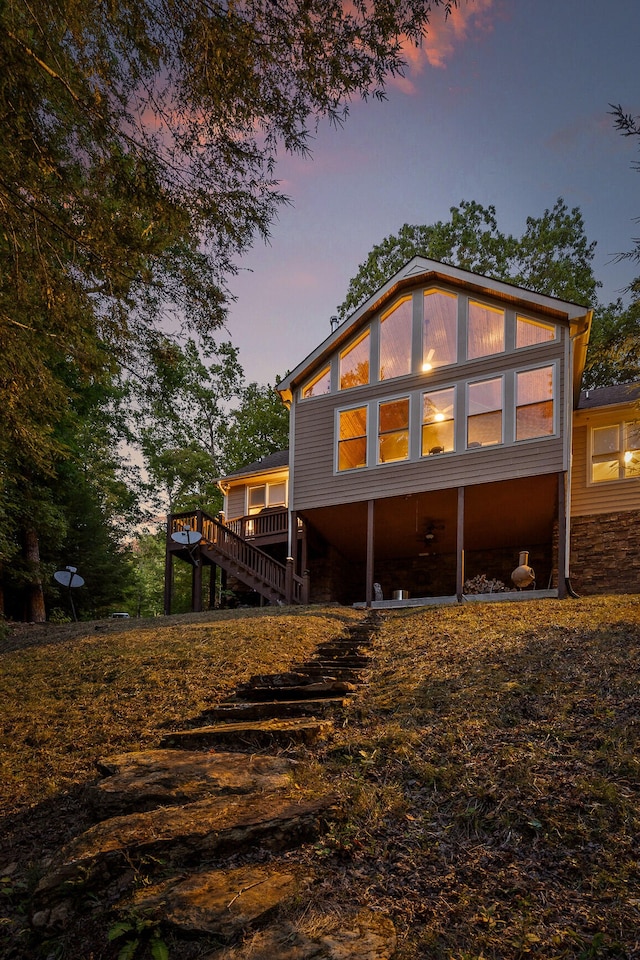 back house at dusk with a wooden deck