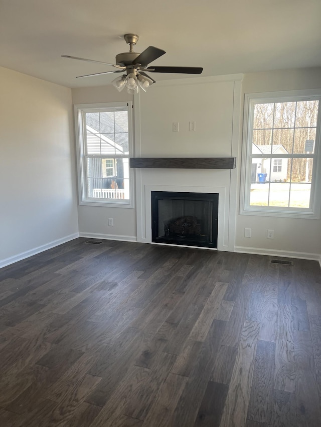 unfurnished living room with dark wood-type flooring and ceiling fan