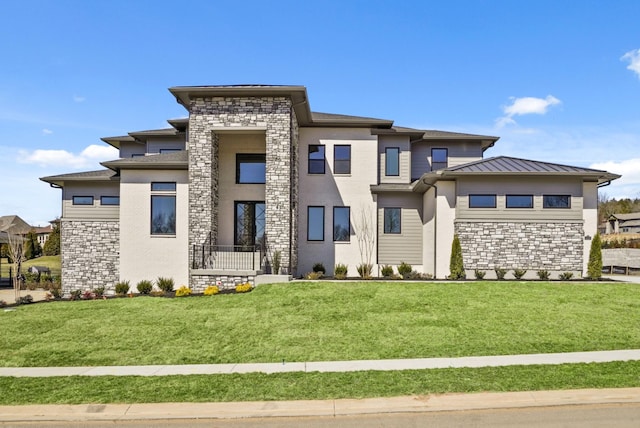 prairie-style home featuring metal roof, stone siding, a front lawn, and a standing seam roof