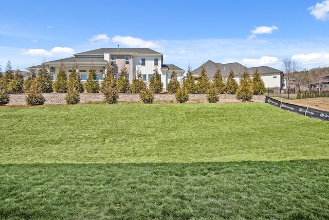 view of home's community featuring a yard and fence