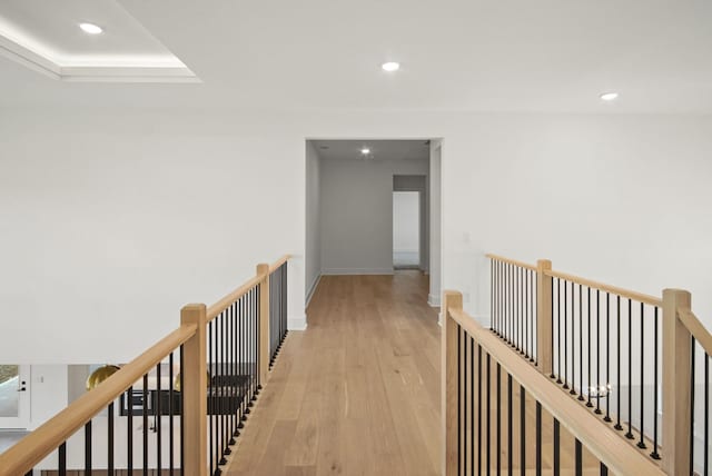 corridor featuring recessed lighting, baseboards, light wood-style flooring, and an upstairs landing