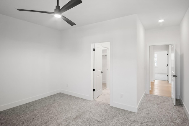 unfurnished bedroom with ceiling fan, baseboards, a walk in closet, and carpet flooring