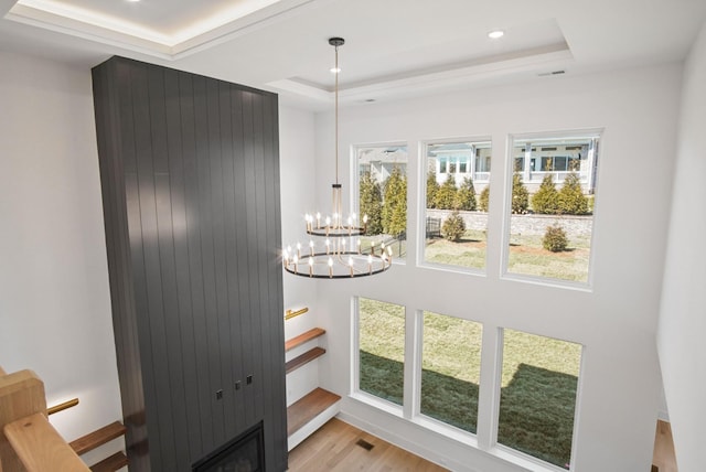 interior space featuring visible vents, an inviting chandelier, a tray ceiling, light wood-type flooring, and recessed lighting