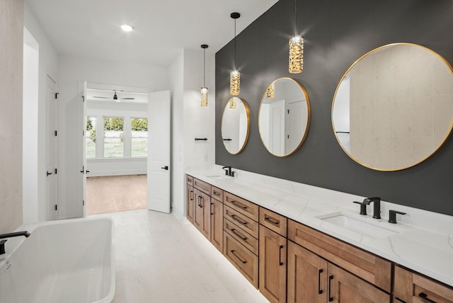 bathroom featuring a freestanding bath, double vanity, and a sink