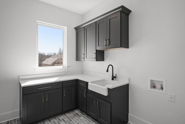 kitchen featuring baseboards, visible vents, light countertops, and a sink