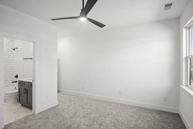 unfurnished bedroom with visible vents, baseboards, connected bathroom, and light colored carpet