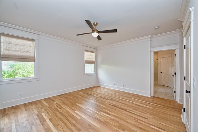 empty room featuring baseboards, a ceiling fan, crown molding, and light wood finished floors