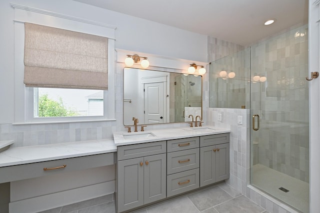 full bathroom featuring a sink, decorative backsplash, double vanity, and a shower stall