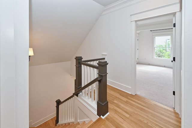 stairway featuring vaulted ceiling, baseboards, and wood finished floors