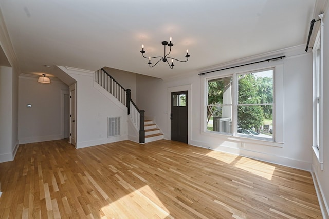 foyer with stairway, baseboards, visible vents, light wood finished floors, and a notable chandelier