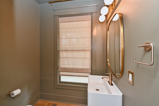 bathroom with a sink and baseboards