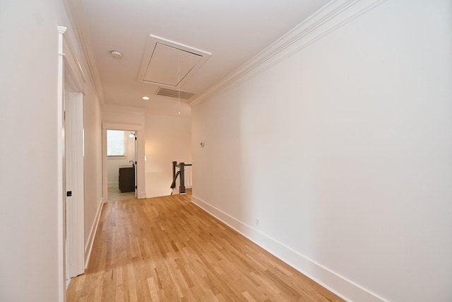 hallway with visible vents, an upstairs landing, ornamental molding, light wood-style flooring, and attic access