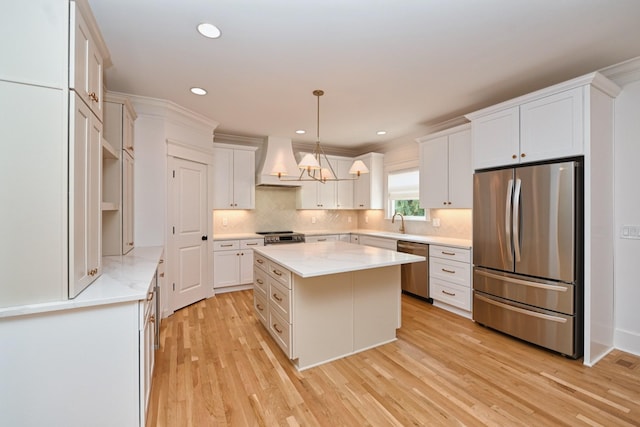 kitchen with a kitchen island, light wood-style floors, custom exhaust hood, white cabinets, and stainless steel appliances