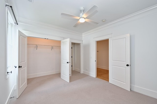 unfurnished bedroom with crown molding, baseboards, a closet, and carpet floors