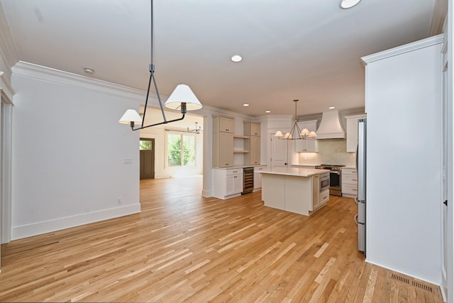 kitchen featuring visible vents, crown molding, premium range hood, wine cooler, and appliances with stainless steel finishes