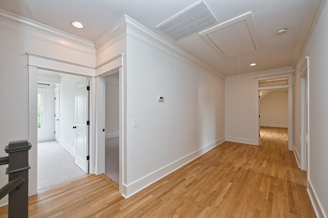 hall featuring visible vents, attic access, ornamental molding, and light wood finished floors