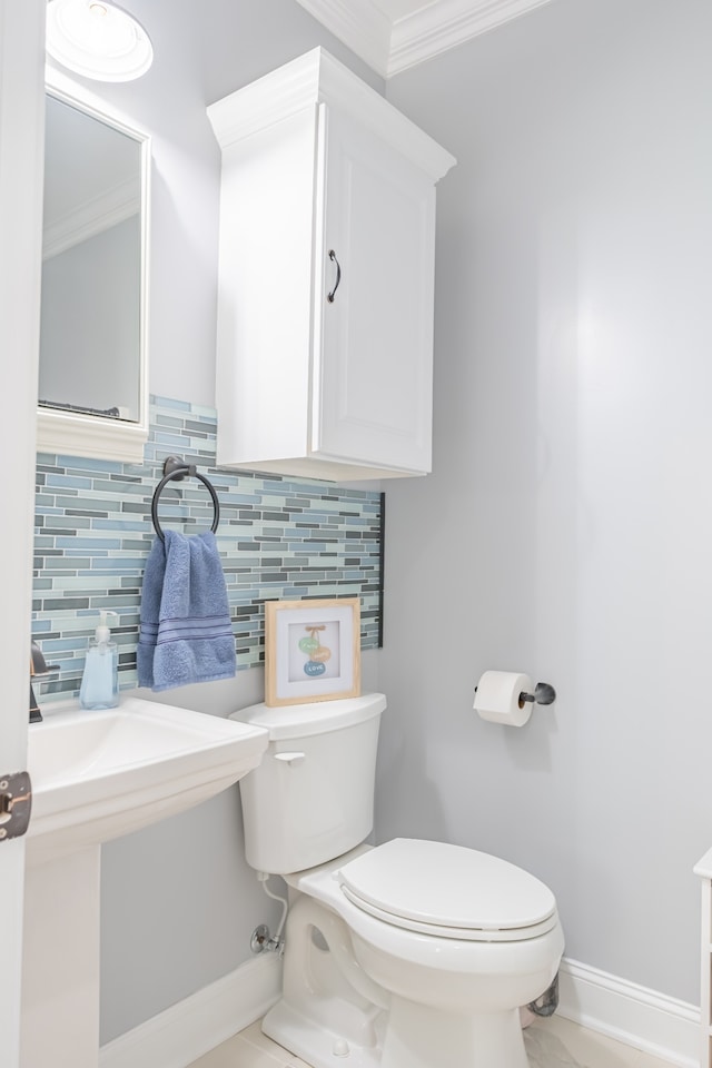 bathroom with backsplash, ornamental molding, and toilet