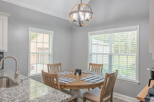 dining room featuring a chandelier, crown molding, and sink