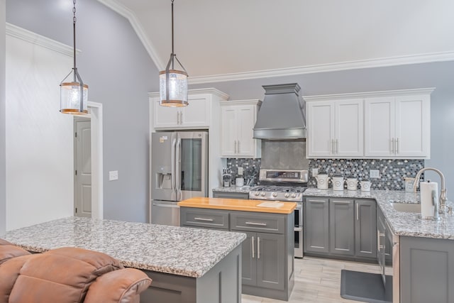 kitchen with gray cabinets, appliances with stainless steel finishes, crown molding, and premium range hood