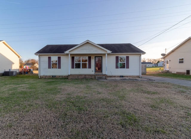 view of front of home with cooling unit and a yard